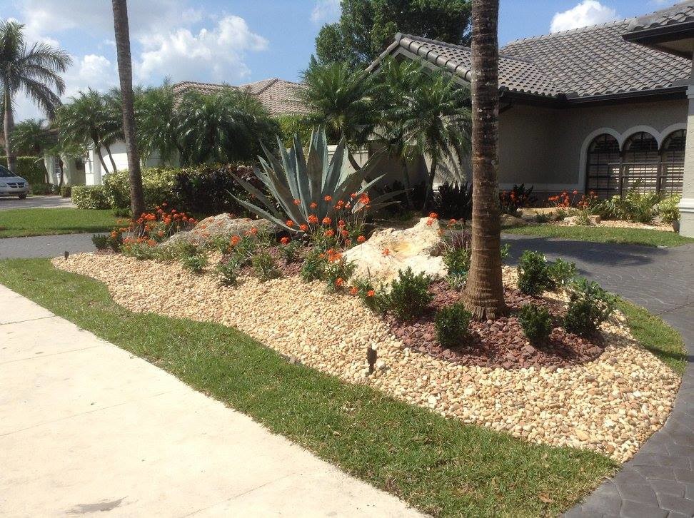 This is an example of a mid-sized full sun front yard gravel landscaping in Miami.