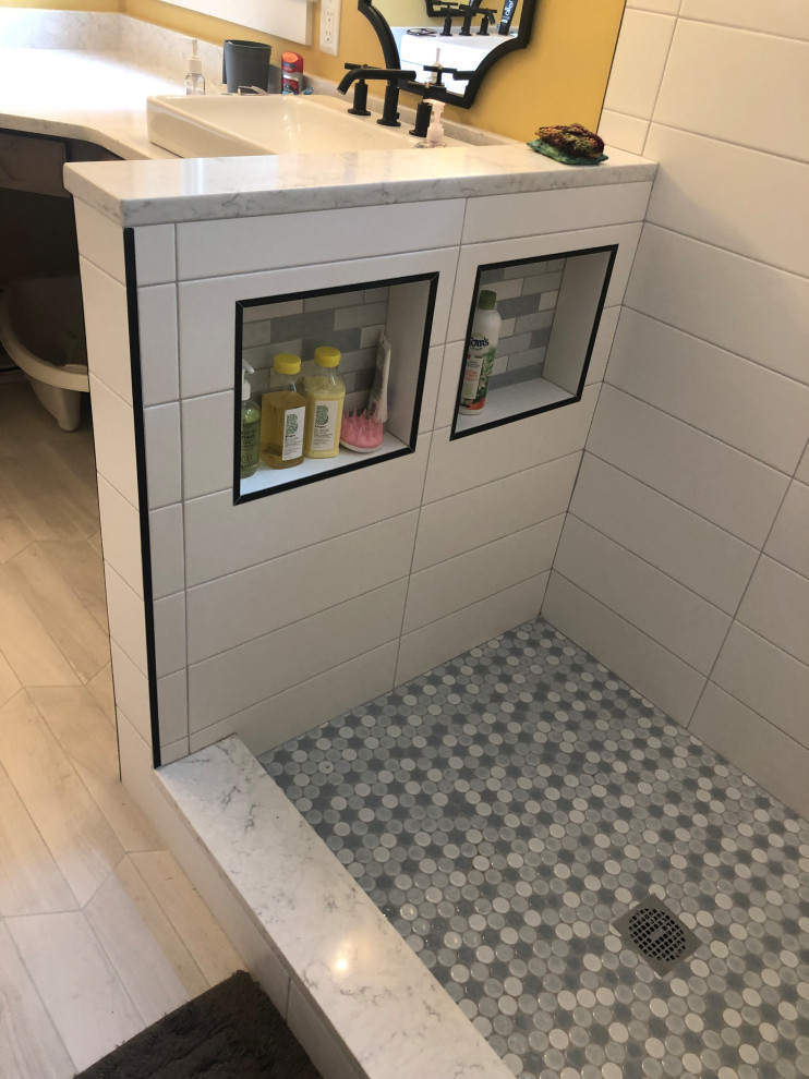 This is an example of a mid-sized traditional powder room in Boston with shaker cabinets, black cabinets, white tile, porcelain tile, grey walls, porcelain floors, an undermount sink, granite benchtops, multi-coloured floor and grey benchtops.