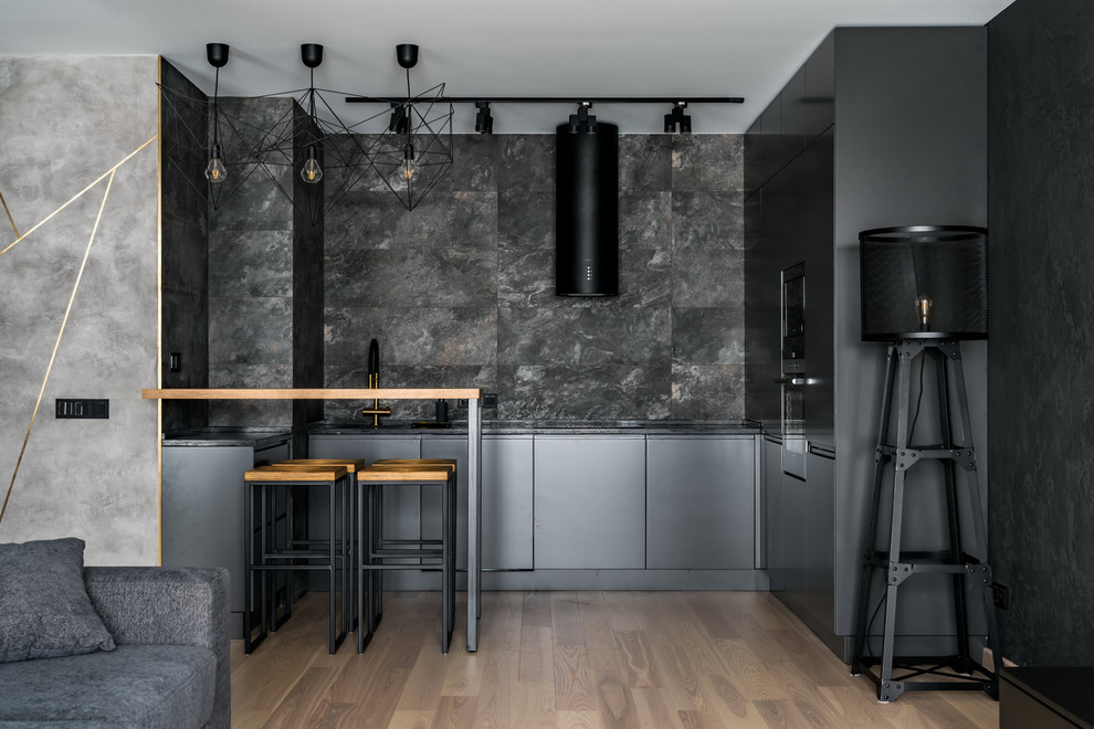 Design ideas for a contemporary open plan kitchen in Moscow with flat-panel cabinets, black cabinets, black splashback, beige floor, black benchtop, light hardwood floors and a peninsula.