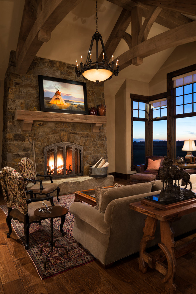 Inspiration for an expansive country open concept living room in Minneapolis with beige walls, medium hardwood floors, a standard fireplace, a stone fireplace surround and no tv.