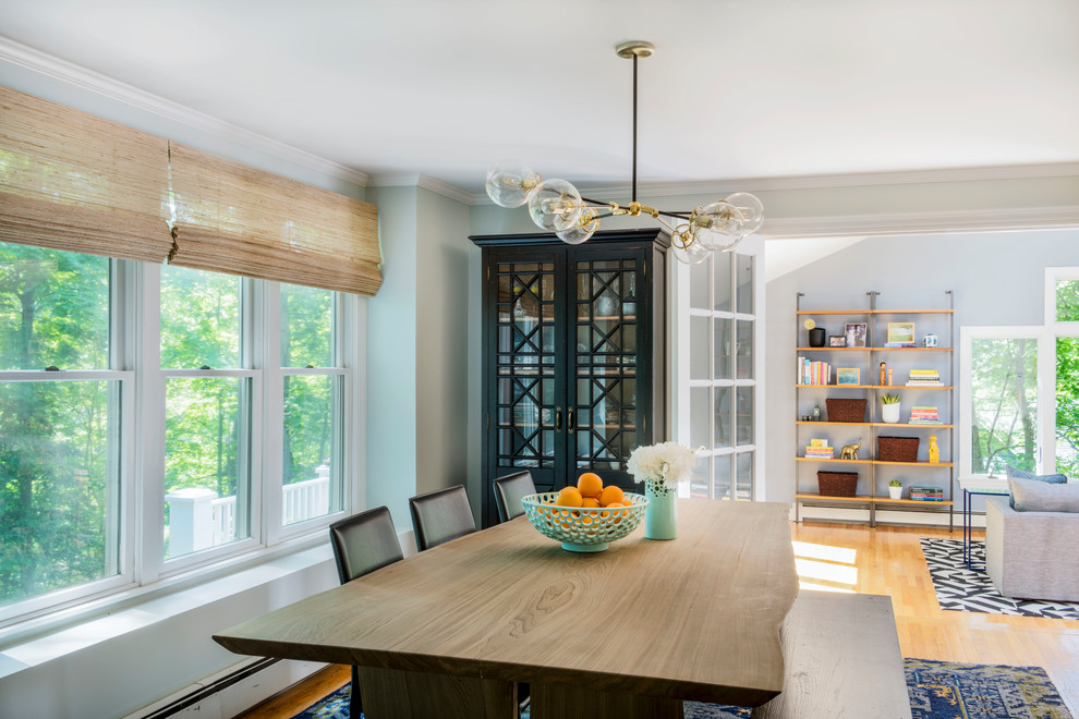 This is an example of a transitional open plan dining in Boston with blue walls, light hardwood floors and brown floor.