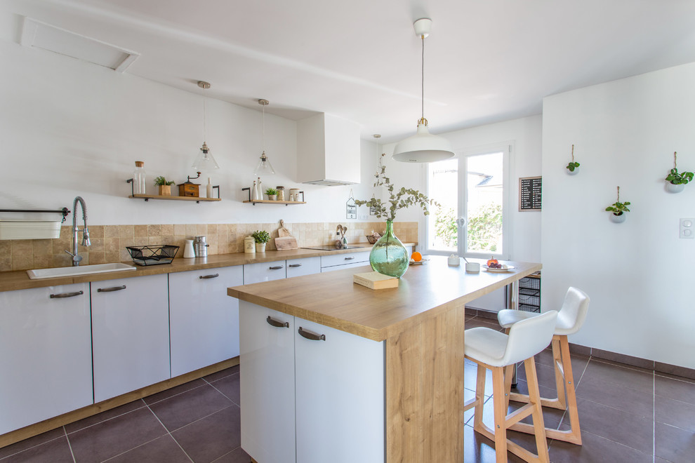 Photo of a large country single-wall eat-in kitchen in Lyon with a single-bowl sink, flat-panel cabinets, white cabinets, laminate benchtops, beige splashback, stone tile splashback, panelled appliances, ceramic floors, with island and brown floor.