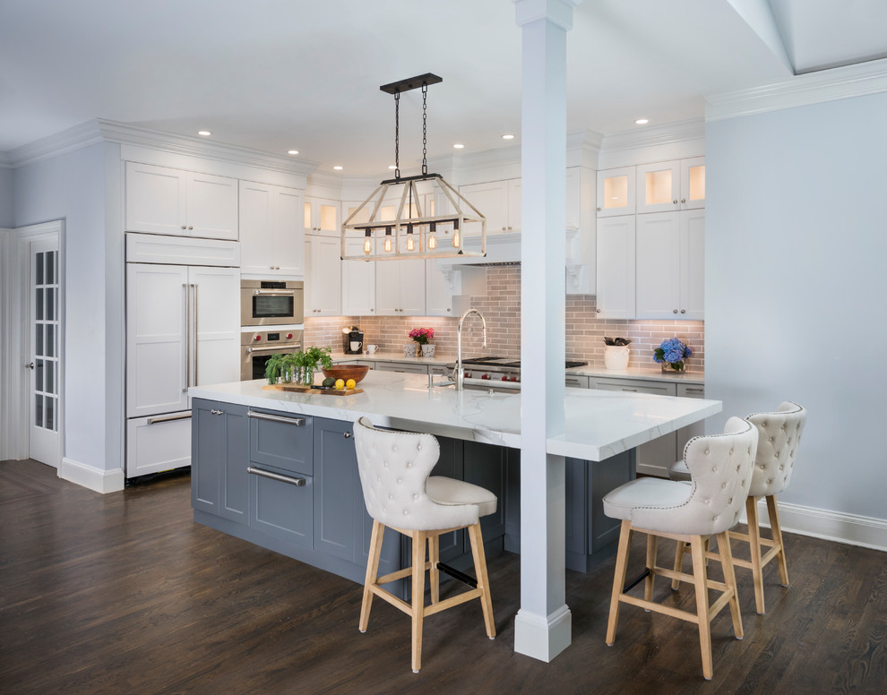 Design ideas for a large transitional l-shaped eat-in kitchen in Boston with an undermount sink, recessed-panel cabinets, white cabinets, marble benchtops, grey splashback, ceramic splashback, stainless steel appliances, medium hardwood floors, with island and brown floor.