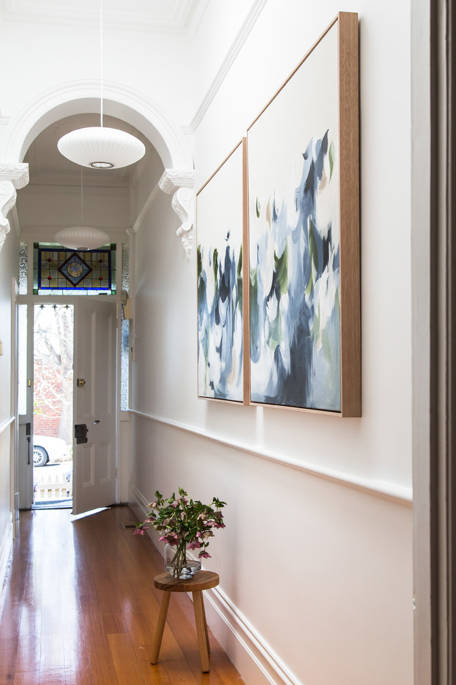 Contemporary hallway in Melbourne with white walls, medium hardwood floors and brown floor.