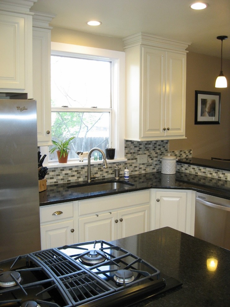 Example of a mid-sized transitional u-shaped dark wood floor enclosed kitchen design in Denver with an undermount sink, raised-panel cabinets, white cabinets, quartzite countertops, multicolored backsplash, matchstick tile backsplash, stainless steel appliances and an island