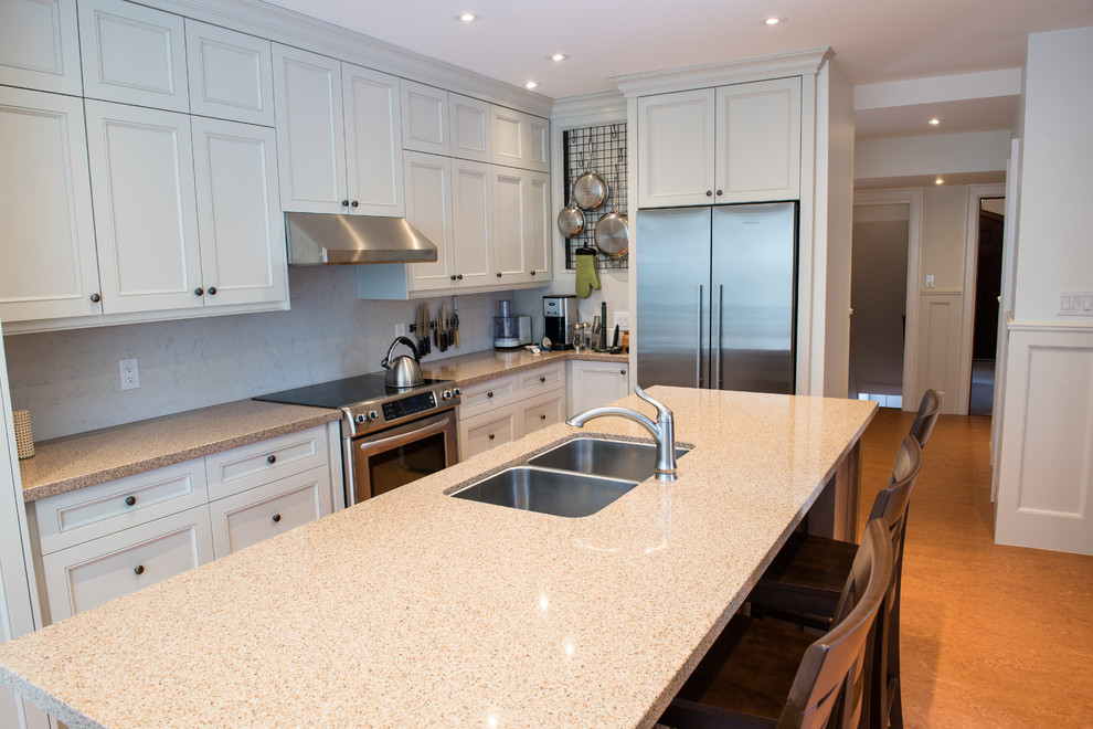 Inspiration for a large traditional l-shaped eat-in kitchen in Toronto with a double-bowl sink, recessed-panel cabinets, beige cabinets, limestone benchtops, white splashback, stone slab splashback, stainless steel appliances, cork floors and with island.
