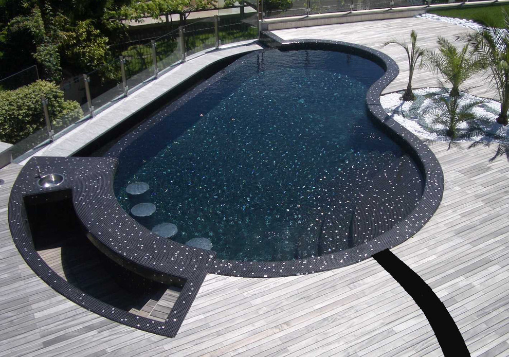 Mid-sized modern rooftop kidney-shaped pool in Miami with decking.