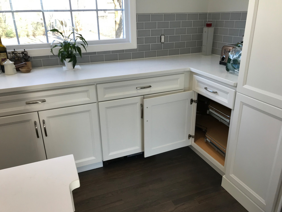 Inspiration for a large transitional u-shaped ceramic tile and gray floor eat-in kitchen remodel with a farmhouse sink, recessed-panel cabinets, white cabinets, quartz countertops, gray backsplash, subway tile backsplash, stainless steel appliances, an island and white countertops