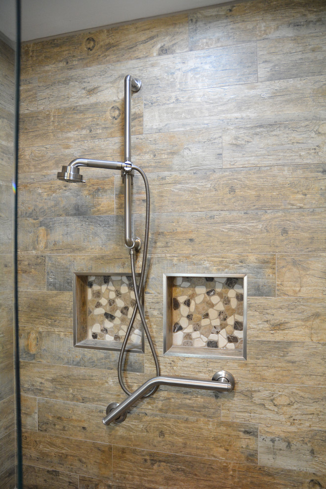 Inspiration for a mid-sized rustic master brown tile and ceramic tile ceramic tile and brown floor alcove shower remodel with raised-panel cabinets, light wood cabinets, a two-piece toilet, beige walls, an integrated sink, marble countertops, a hinged shower door and gray countertops