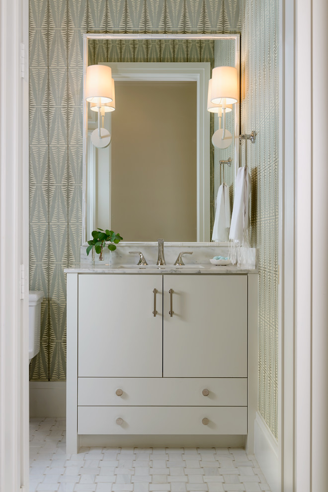 Photo of a mid-sized transitional powder room in Dallas with flat-panel cabinets, white cabinets, a one-piece toilet, white tile, porcelain tile, green walls, porcelain floors, an undermount sink and marble benchtops.