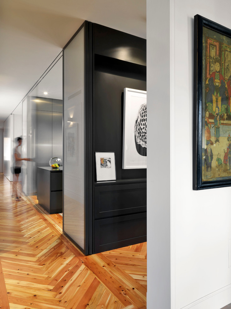 Inspiration for a mid-sized contemporary hallway in Madrid with white walls and medium hardwood floors.