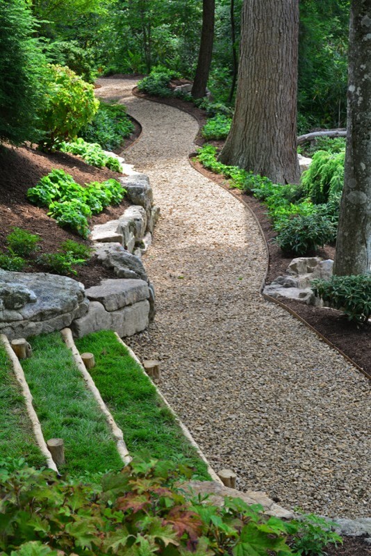 Large traditional backyard partial sun garden in Other with a garden path and gravel.