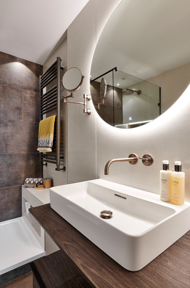 Mid-sized modern master bathroom in Cardiff with open cabinets, dark wood cabinets, an open shower, a wall-mount toilet, brown tile, porcelain tile, beige walls, porcelain floors, brown floor and an open shower.