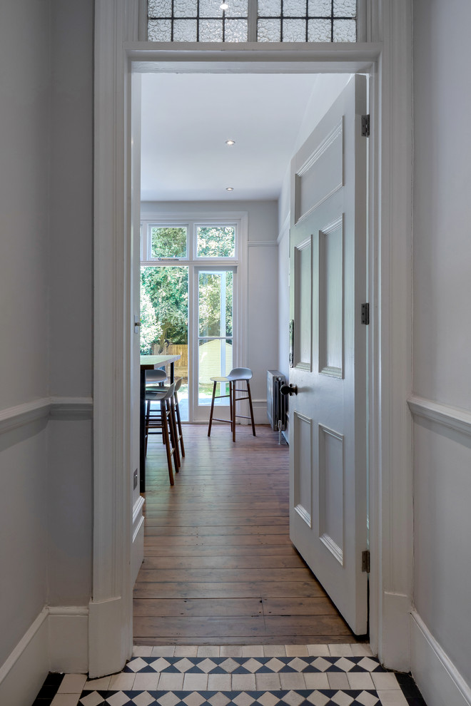 This is an example of a mid-sized traditional hallway in London with beige walls, porcelain floors and multi-coloured floor.