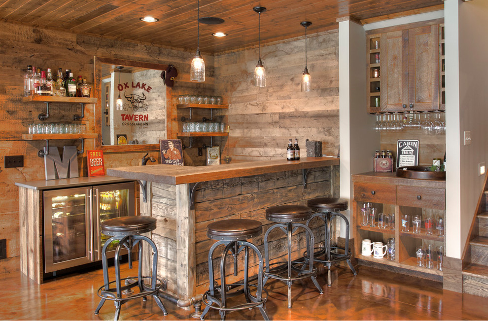 Photo of a country galley seated home bar in Minneapolis with wood benchtops, concrete floors, brown floor and brown benchtop.