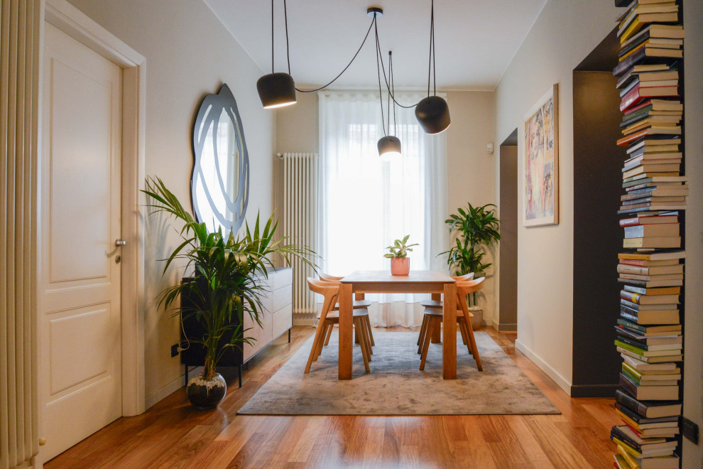 Immagine di una sala da pranzo aperta verso il soggiorno minimal di medie dimensioni con pareti beige e parquet chiaro