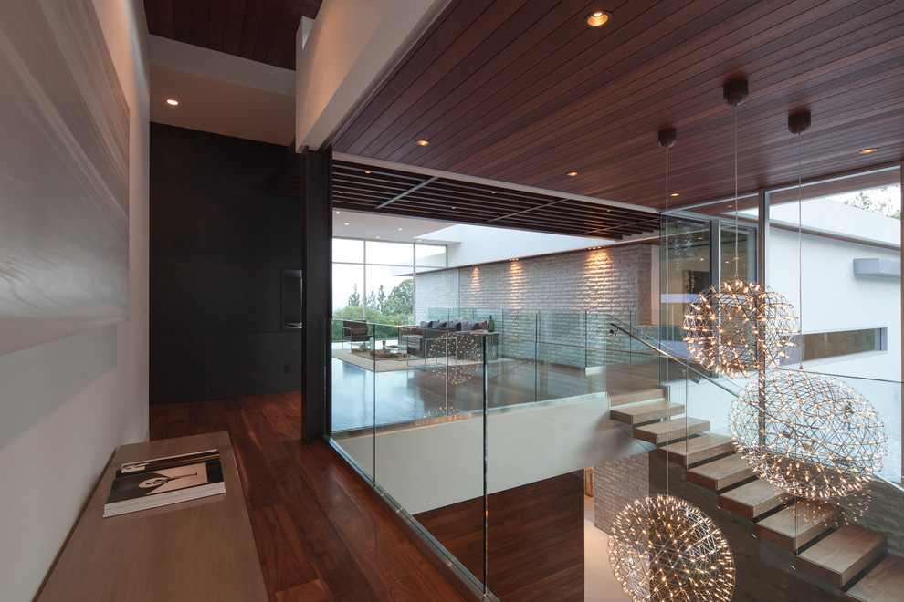 This is an example of an expansive modern hallway in Los Angeles with dark hardwood floors.