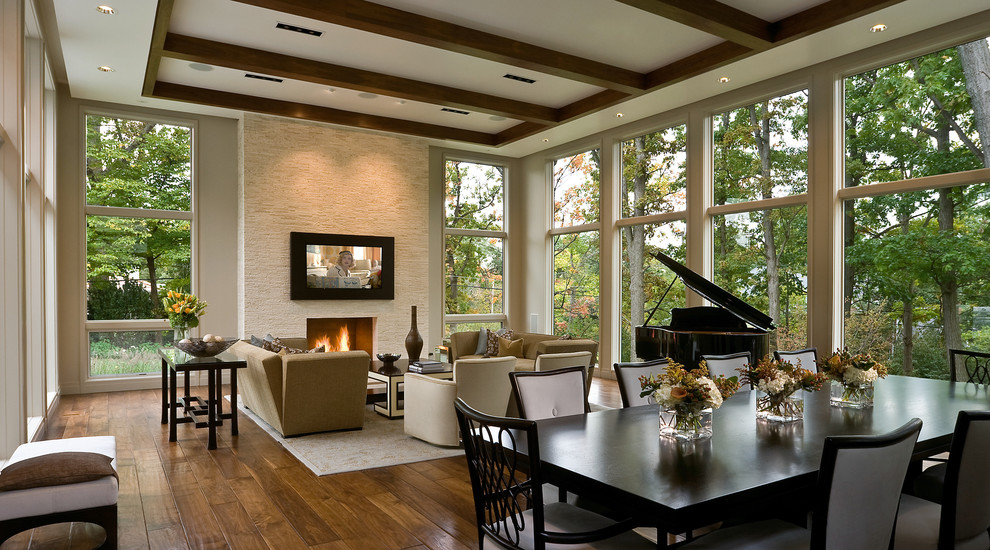 Photo of a traditional living room in Chicago with dark hardwood floors, a standard fireplace, a stone fireplace surround and a built-in media wall.