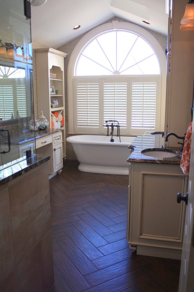 Design ideas for a large traditional master bathroom in Charlotte with an undermount sink, furniture-like cabinets, marble benchtops, a freestanding tub, a corner shower, a one-piece toilet, porcelain tile and porcelain floors.