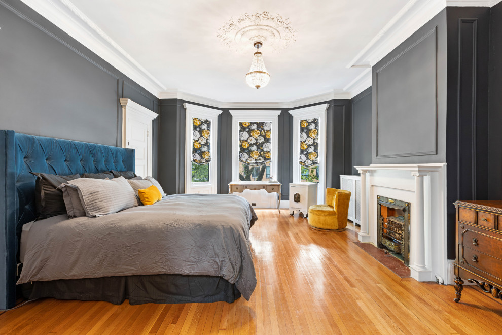ニューヨークにある広いコンテンポラリースタイルのおしゃれな主寝室 (グレーの壁、淡色無垢フローリング、標準型暖炉、金属の暖炉まわり、茶色い床、三角天井、羽目板の壁、アクセントウォール、白い天井)