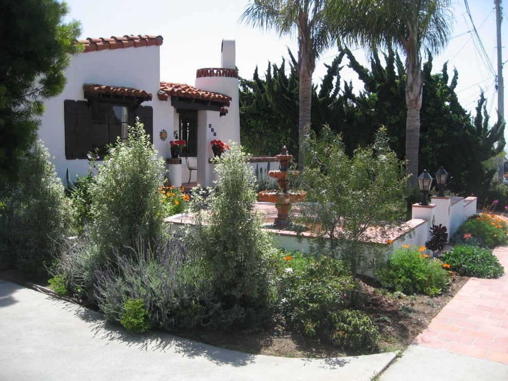 This is an example of a mediterranean front yard shaded outdoor sport court in Orange County with concrete pavers.