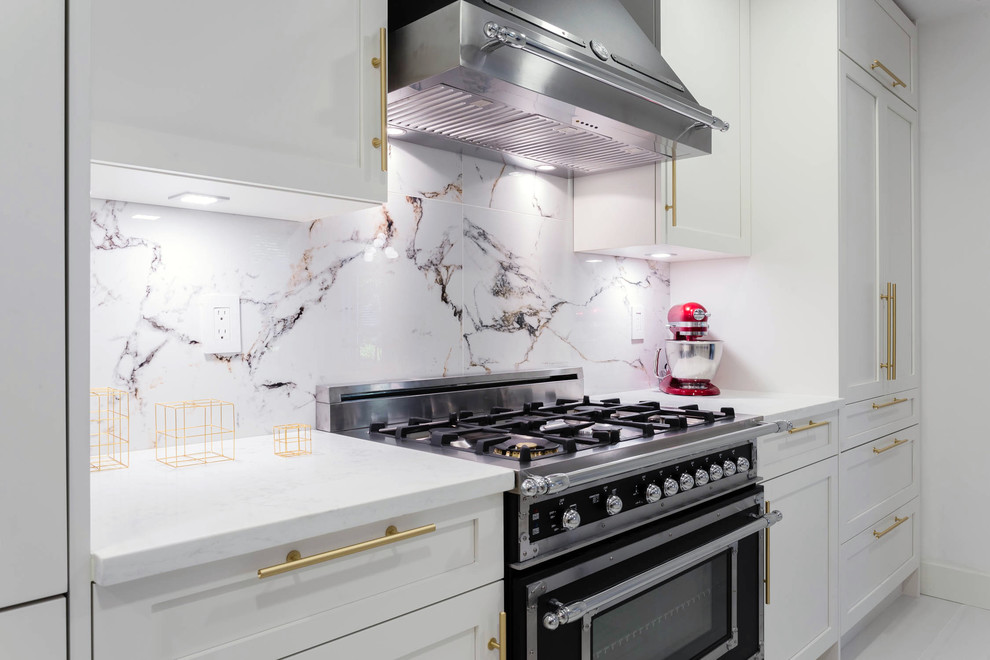 Inspiration for a mid-sized contemporary galley open plan kitchen in Vancouver with a single-bowl sink, shaker cabinets, white cabinets, quartz benchtops, white splashback, porcelain splashback, black appliances, porcelain floors, a peninsula and white floor.