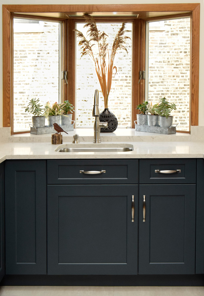 Open concept kitchen - mid-sized transitional u-shaped porcelain tile and white floor open concept kitchen idea in Chicago with a single-bowl sink, shaker cabinets, blue cabinets, quartz countertops, multicolored backsplash, glass tile backsplash, stainless steel appliances and a peninsula