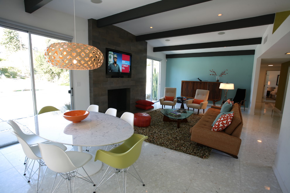 Midcentury living room in Orange County with blue walls and a standard fireplace.