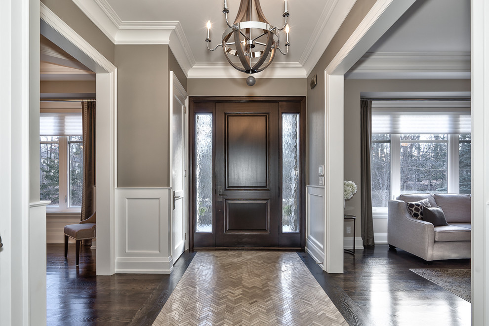 Photo of a large contemporary foyer in Toronto with grey walls, marble floors and a dark wood front door.