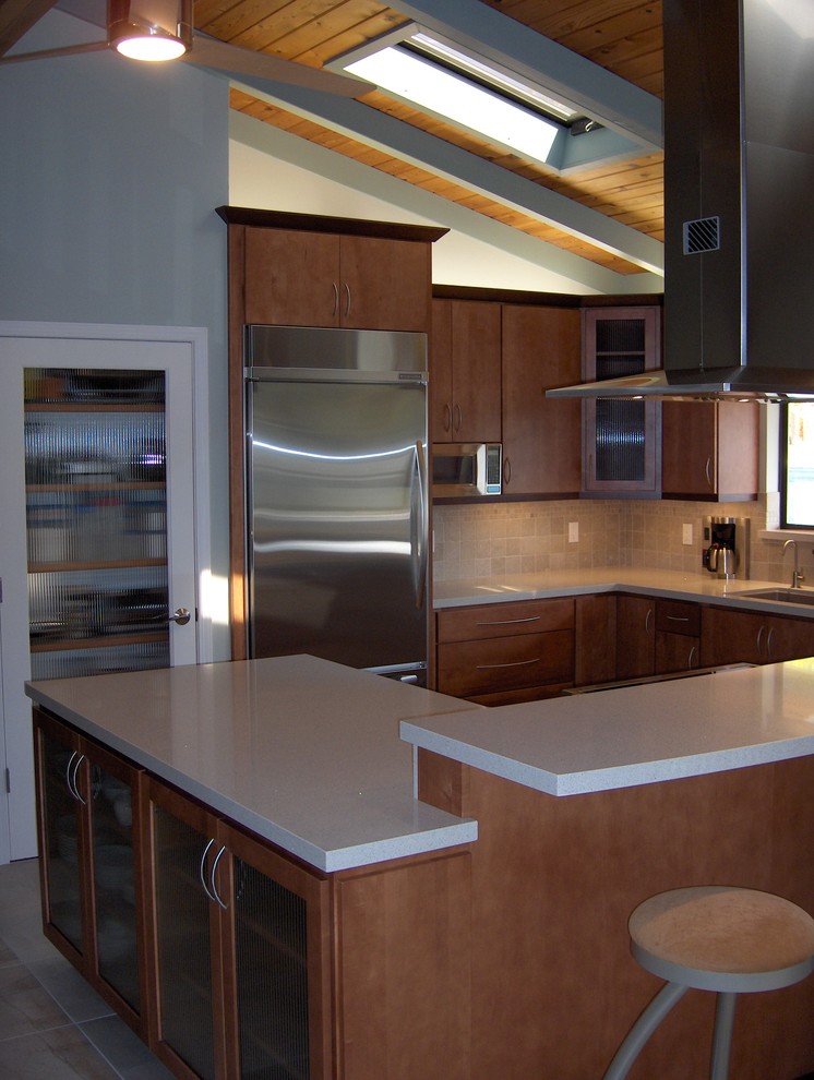 Photo of a mid-sized contemporary eat-in kitchen in San Francisco with an undermount sink, flat-panel cabinets, medium wood cabinets, quartz benchtops, grey splashback, stone tile splashback, stainless steel appliances, porcelain floors and with island.