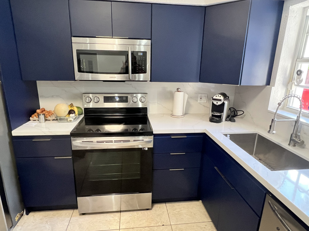 На фото: угловая кухня среднего размера в стиле модернизм с плоскими фасадами и синими фасадами с