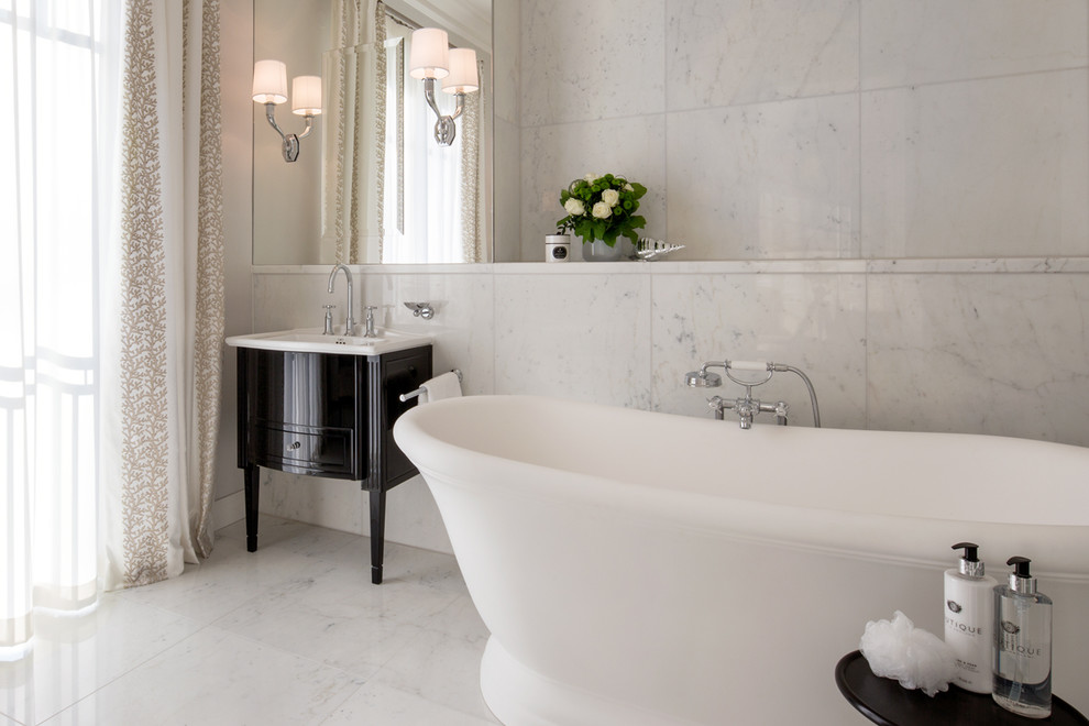 Inspiration for a large traditional master bathroom in Berlin with black cabinets, a freestanding tub, white tile, a drop-in sink, a curbless shower, a two-piece toilet, marble, grey walls, marble floors, marble benchtops, grey floor, a hinged shower door and recessed-panel cabinets.