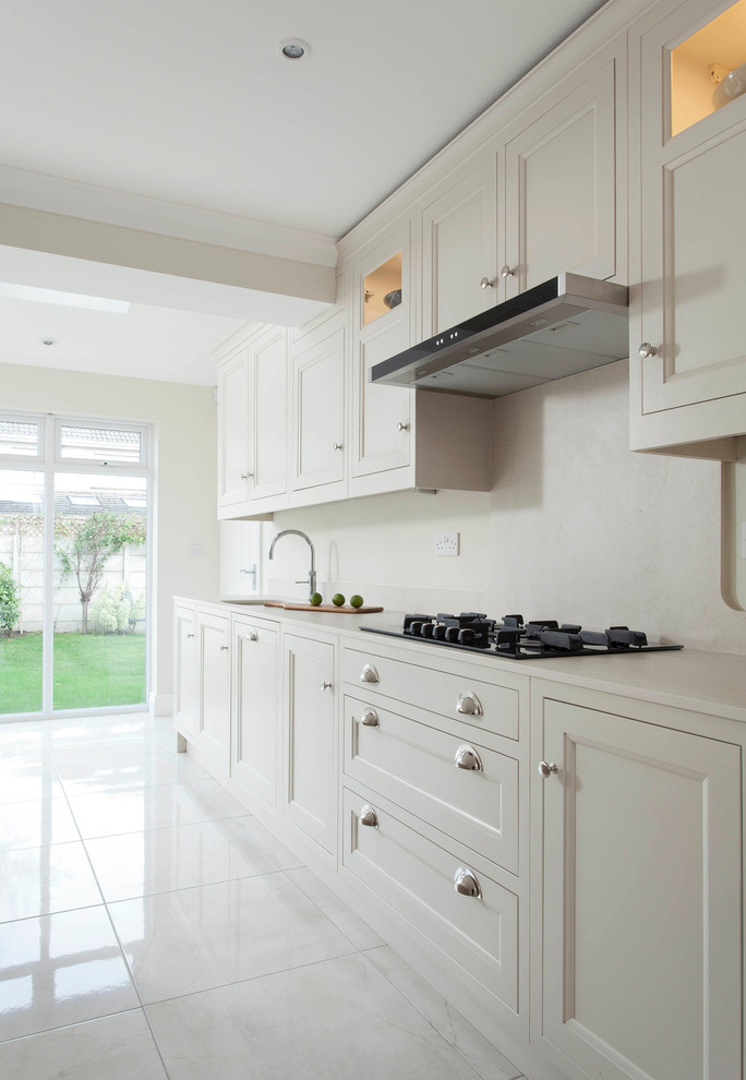Photo of a large transitional single-wall open plan kitchen in Dublin with an undermount sink, beaded inset cabinets, beige cabinets, quartzite benchtops, beige splashback, stone slab splashback, stainless steel appliances, porcelain floors and with island.