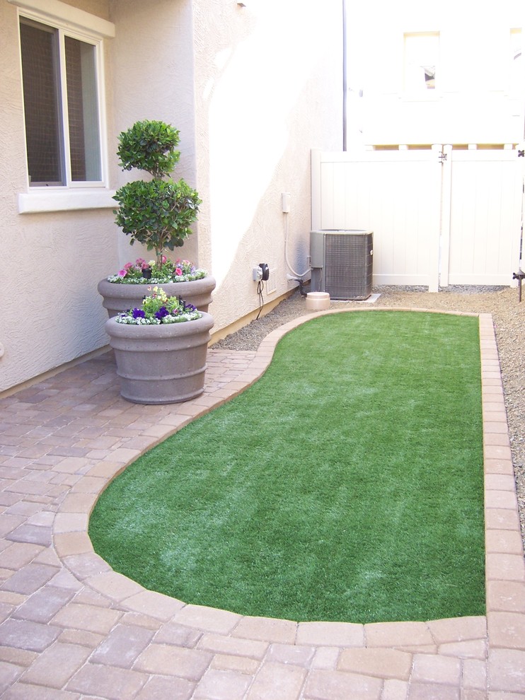 Small arts and crafts courtyard shaded outdoor sport court in Phoenix with concrete pavers.