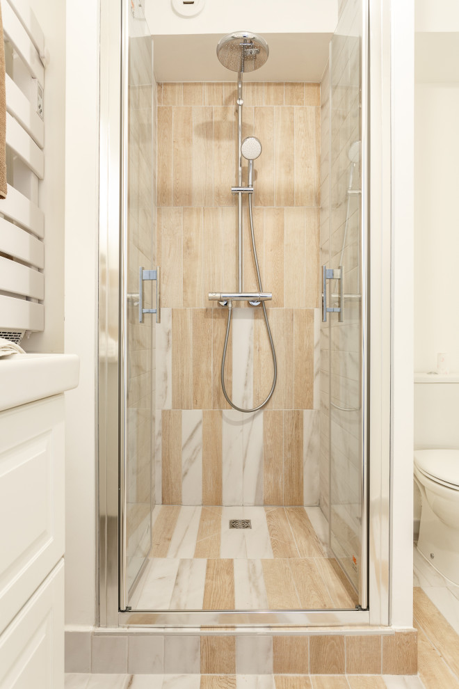 Example of a small danish 3/4 beige tile and ceramic tile ceramic tile and beige floor alcove shower design in Paris with white cabinets, a one-piece toilet, white walls and a freestanding vanity