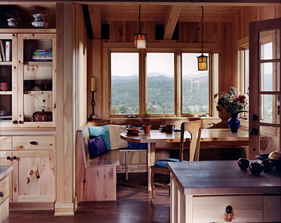 Photo of a small country u-shaped eat-in kitchen in Denver with flat-panel cabinets, light wood cabinets, wood benchtops and medium hardwood floors.