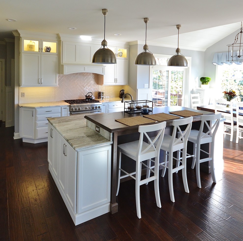 This is an example of an expansive transitional l-shaped eat-in kitchen in Philadelphia with an undermount sink, raised-panel cabinets, white cabinets, granite benchtops, white splashback, subway tile splashback, panelled appliances, dark hardwood floors, with island and brown floor.