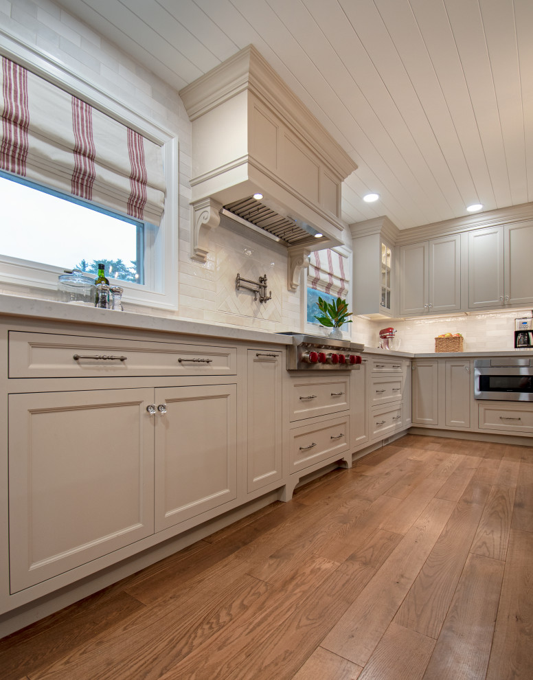 Kitchen - transitional medium tone wood floor, brown floor and shiplap ceiling kitchen idea with shaker cabinets, beige cabinets, quartz countertops, white backsplash, ceramic backsplash, stainless steel appliances and white countertops