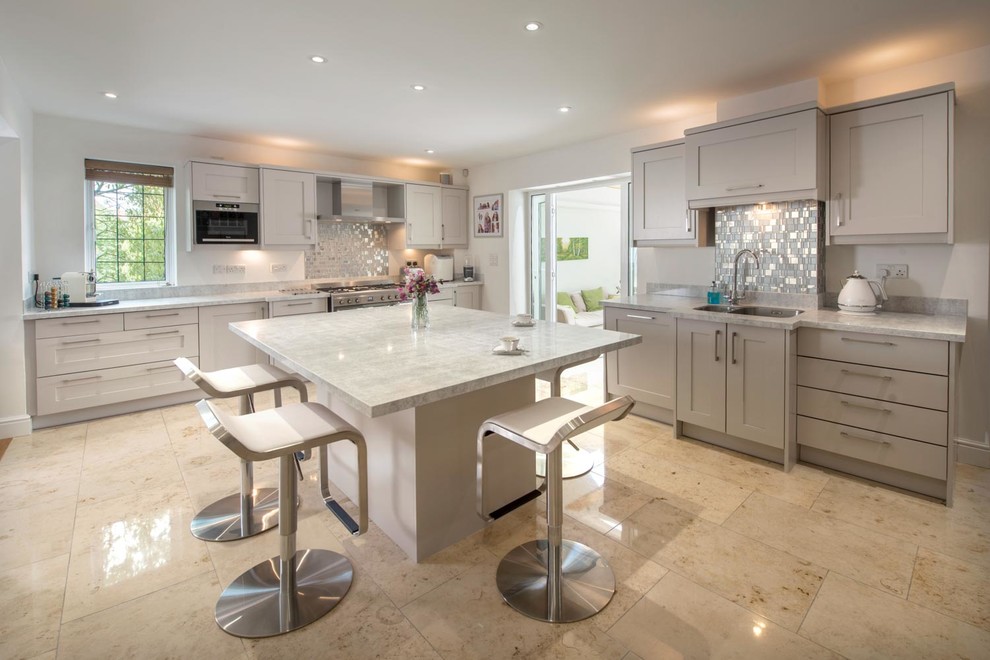 Enclosed kitchen - mid-sized transitional l-shaped travertine floor enclosed kitchen idea with a double-bowl sink, shaker cabinets, beige cabinets, marble countertops, metallic backsplash, metal backsplash, stainless steel appliances and an island