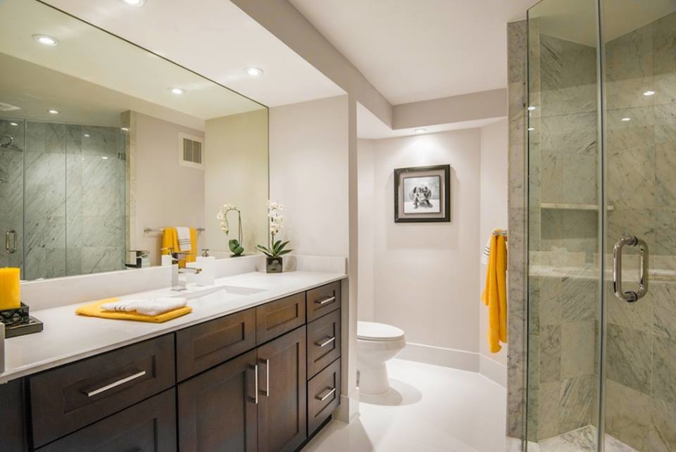 Inspiration for a modern bathroom in Miami with an undermount sink, shaker cabinets, dark wood cabinets, engineered quartz benchtops, an alcove shower, a one-piece toilet, white tile, porcelain tile, grey walls and porcelain floors.