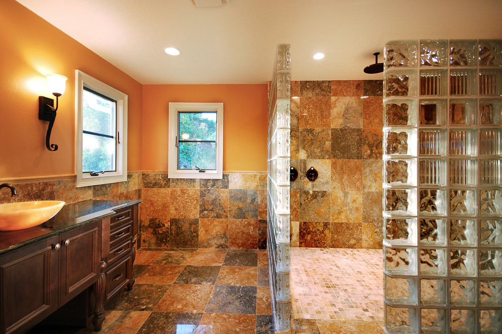 Inspiration for a mid-sized eclectic master bathroom in Orlando with recessed-panel cabinets, dark wood cabinets, a curbless shower, multi-coloured tile, ceramic tile, orange walls, porcelain floors and granite benchtops.
