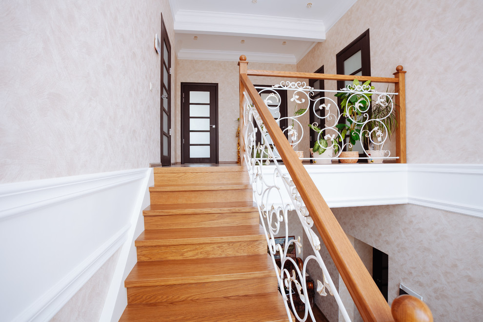 This is an example of a large transitional wood u-shaped staircase in Other with wood risers and mixed railing.