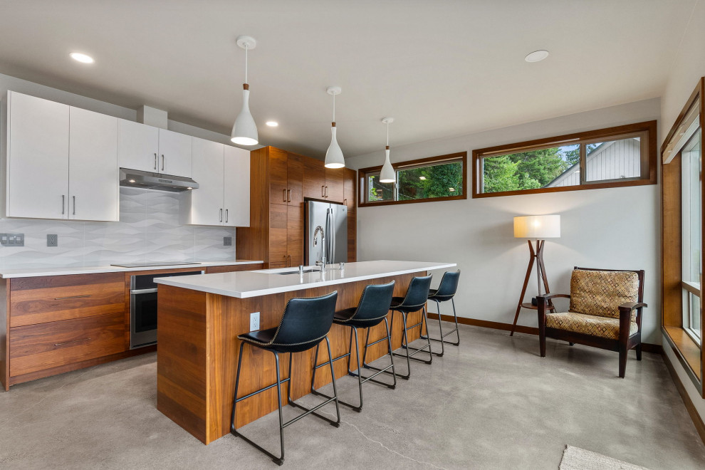 Design ideas for a mid-sized transitional eat-in kitchen in Seattle with flat-panel cabinets, quartz benchtops, stainless steel appliances and with island.