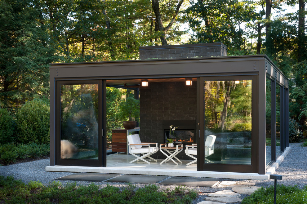This is an example of a small modern back patio in Boston with concrete slabs and a roof extension.