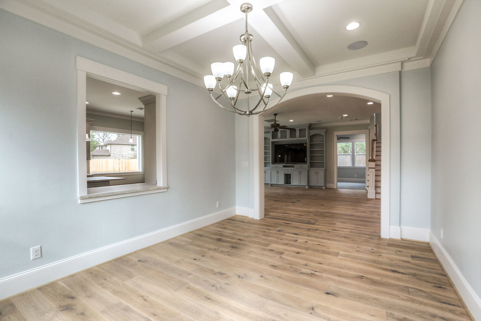Inspiration for a large transitional light wood floor and beige floor enclosed dining room remodel in Houston with blue walls and no fireplace