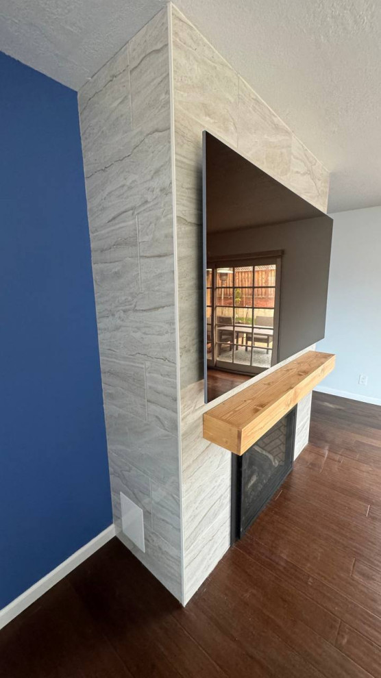 Mittelgroßes, Repräsentatives Modernes Wohnzimmer im Loft-Stil mit blauer Wandfarbe, Sperrholzboden, Kamin, gefliester Kaminumrandung, TV-Wand und braunem Boden in San Francisco