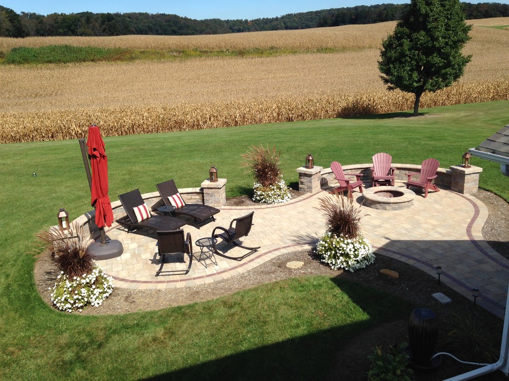 Inspiration for a mid-sized traditional backyard patio in Cleveland with brick pavers, no cover and a fire feature.