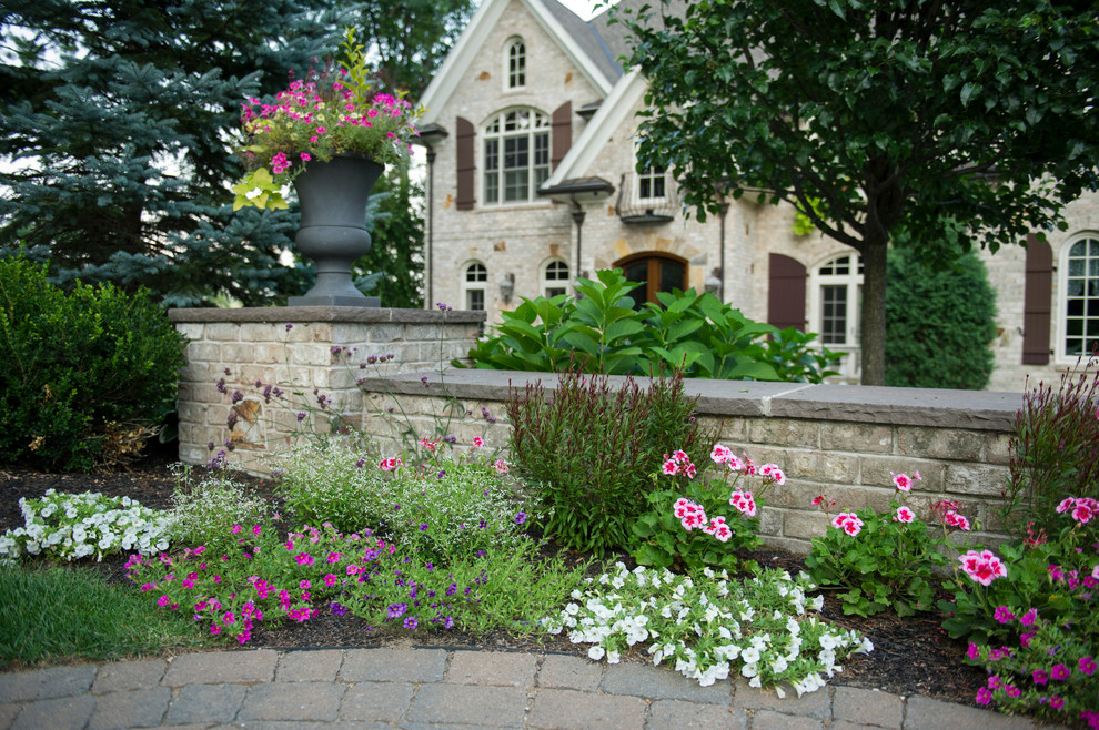 Large traditional front yard partial sun formal garden in Boston with brick pavers and a retaining wall for summer.