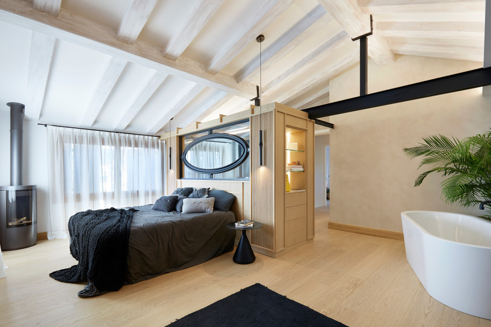 Aménagement d'une chambre parentale contemporaine de taille moyenne avec un mur beige, parquet clair, un poêle à bois, un sol marron et poutres apparentes.