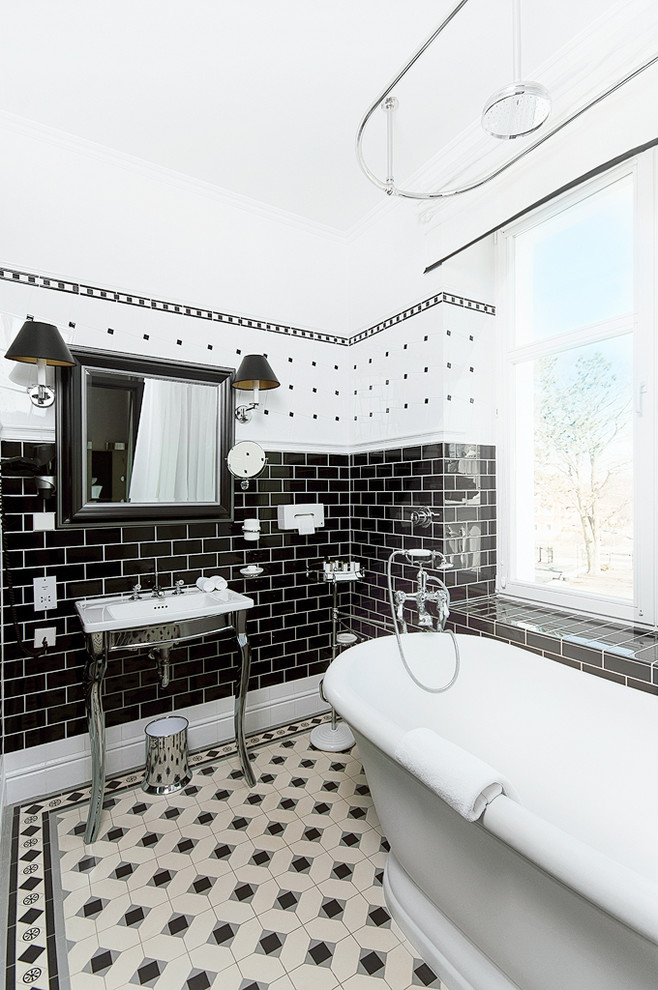 Design ideas for a traditional bathroom in Other with a console sink, a freestanding tub, subway tile and black and white tile.